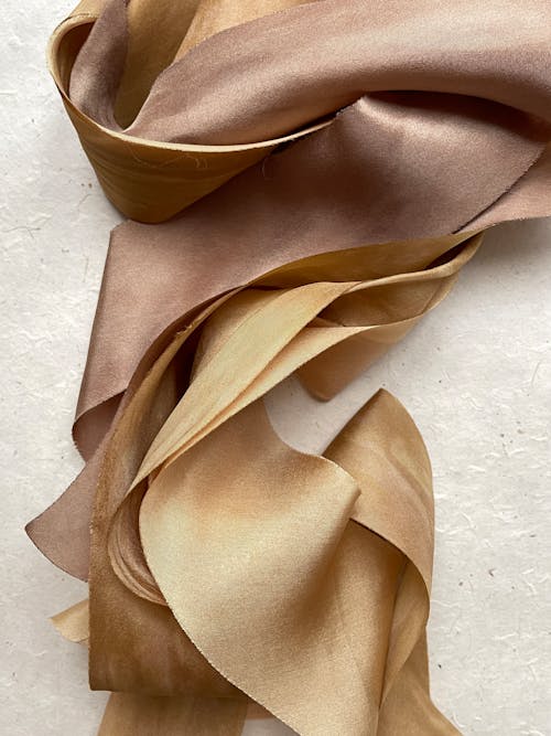 Free Gold Satin Fabric on a White Surface Stock Photo