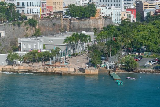 Aerial view of a coastal town with historic buildings and vibrant greenery along the shore.