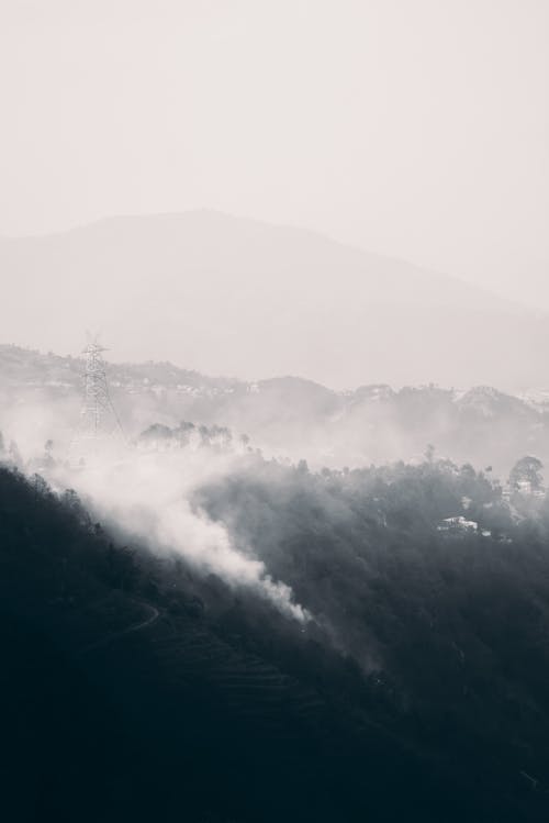 Aerial View of Mountains with Peaks Covered by Dense Fog 