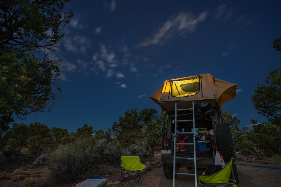 Experience a night under the stars in Moab with a rooftop tent and cozy camp setup.