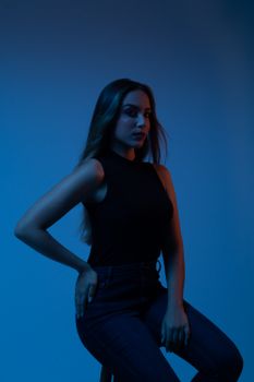 Moody studio portrait of a young woman in a dark color palette.