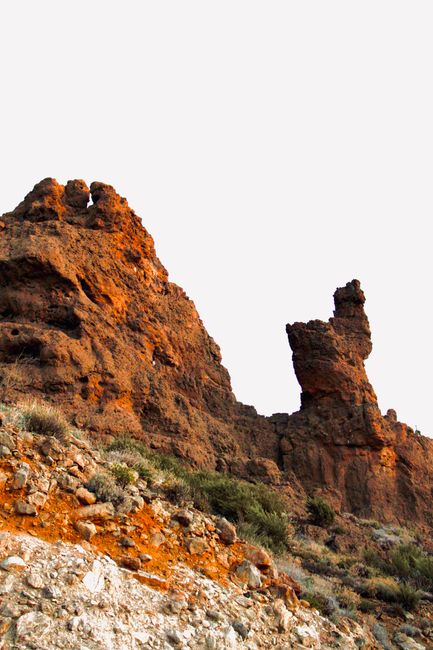 Eroded rock formations rise against a clear sky, showcasing nature's sculpting power.