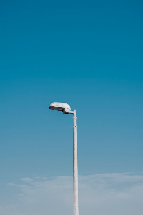 Free Minimalist shot of a single street lamp with a clear blue sky, exemplifying urban simplicity in Dubai. Stock Photo