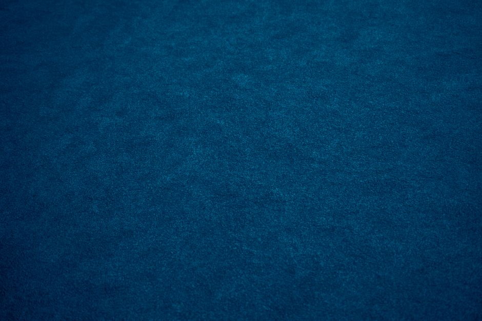 Close-up of deep blue fabric texture providing ideal copyspace for design projects.