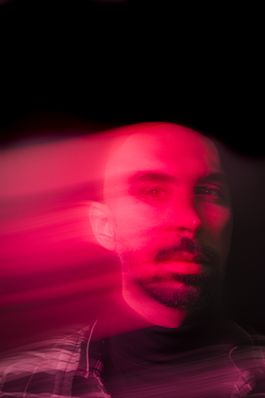 Free Blurred portrait of a bearded man with artistic pink light trails creating a dramatic effect. Stock Photo