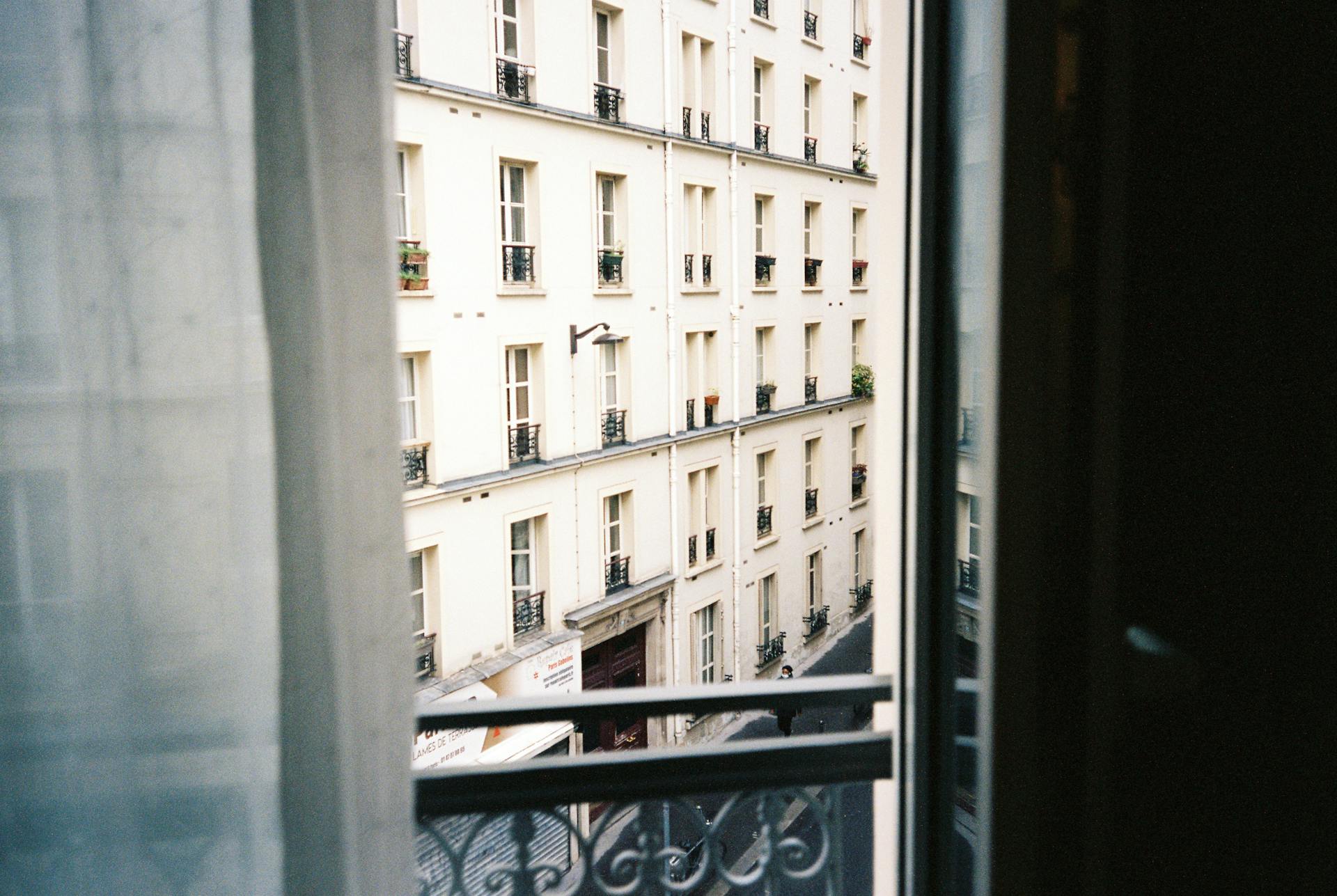 View of a Parisian street from a balcony, showcasing classic French architecture and a serene atmosphere.