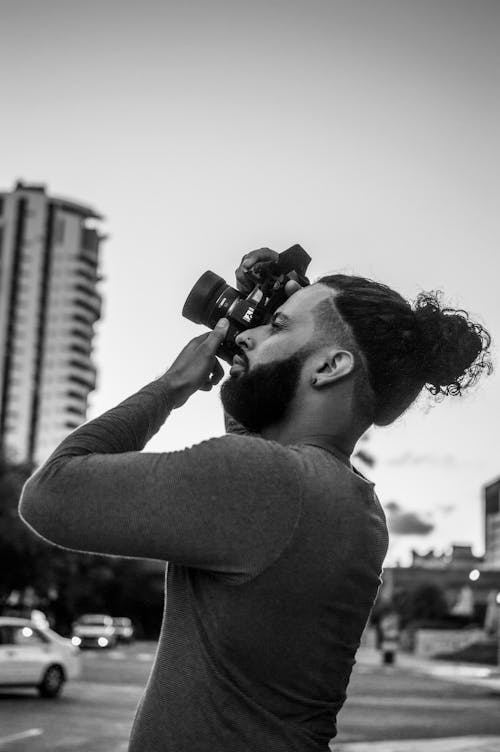 Grayscale Photo of a Man Taking a Picture 