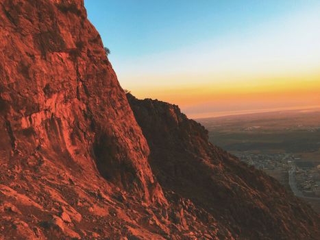 A breathtaking view of rugged rock formations against a vivid sunset sky.