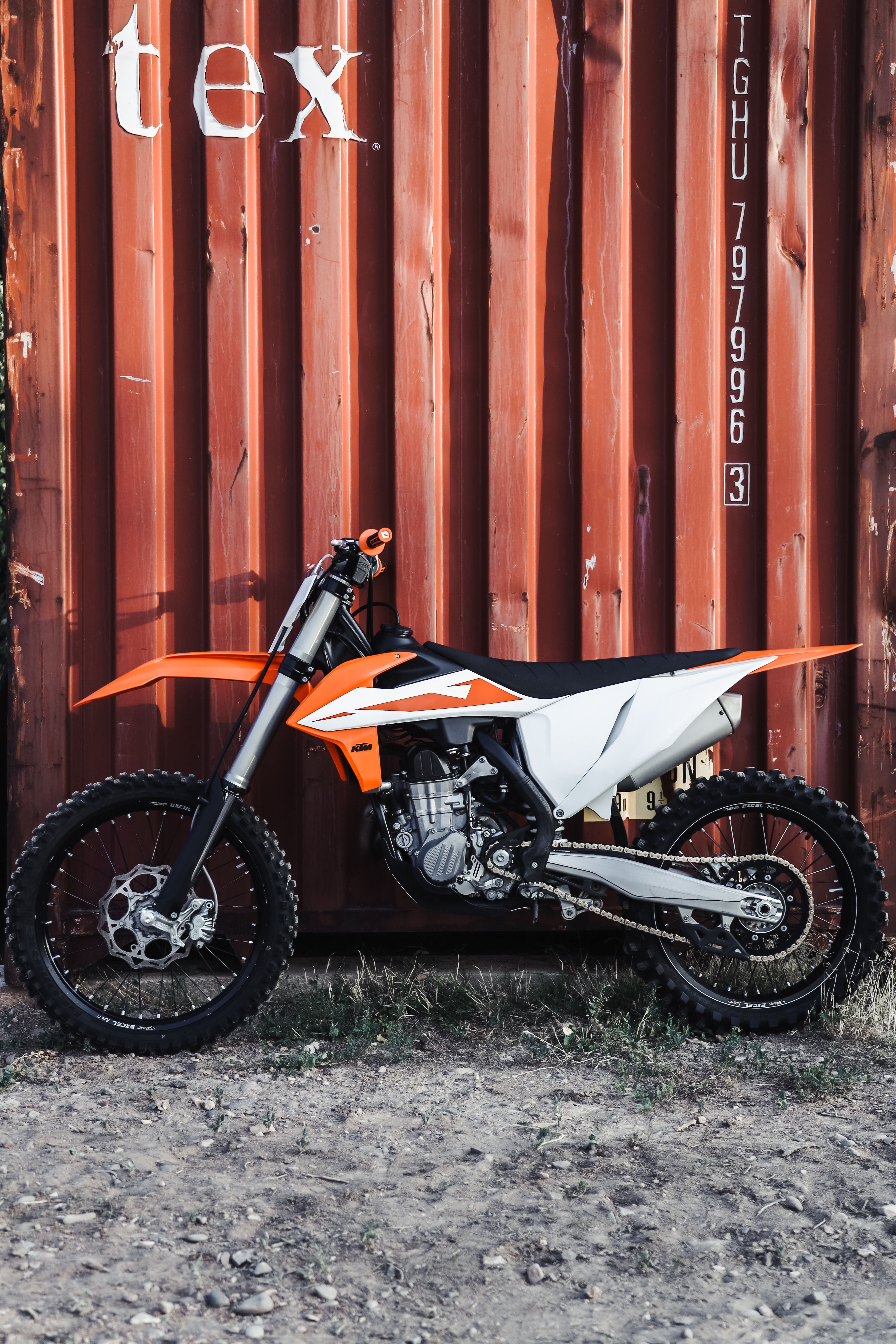 Motocross Parked by Container · Free Stock Photo