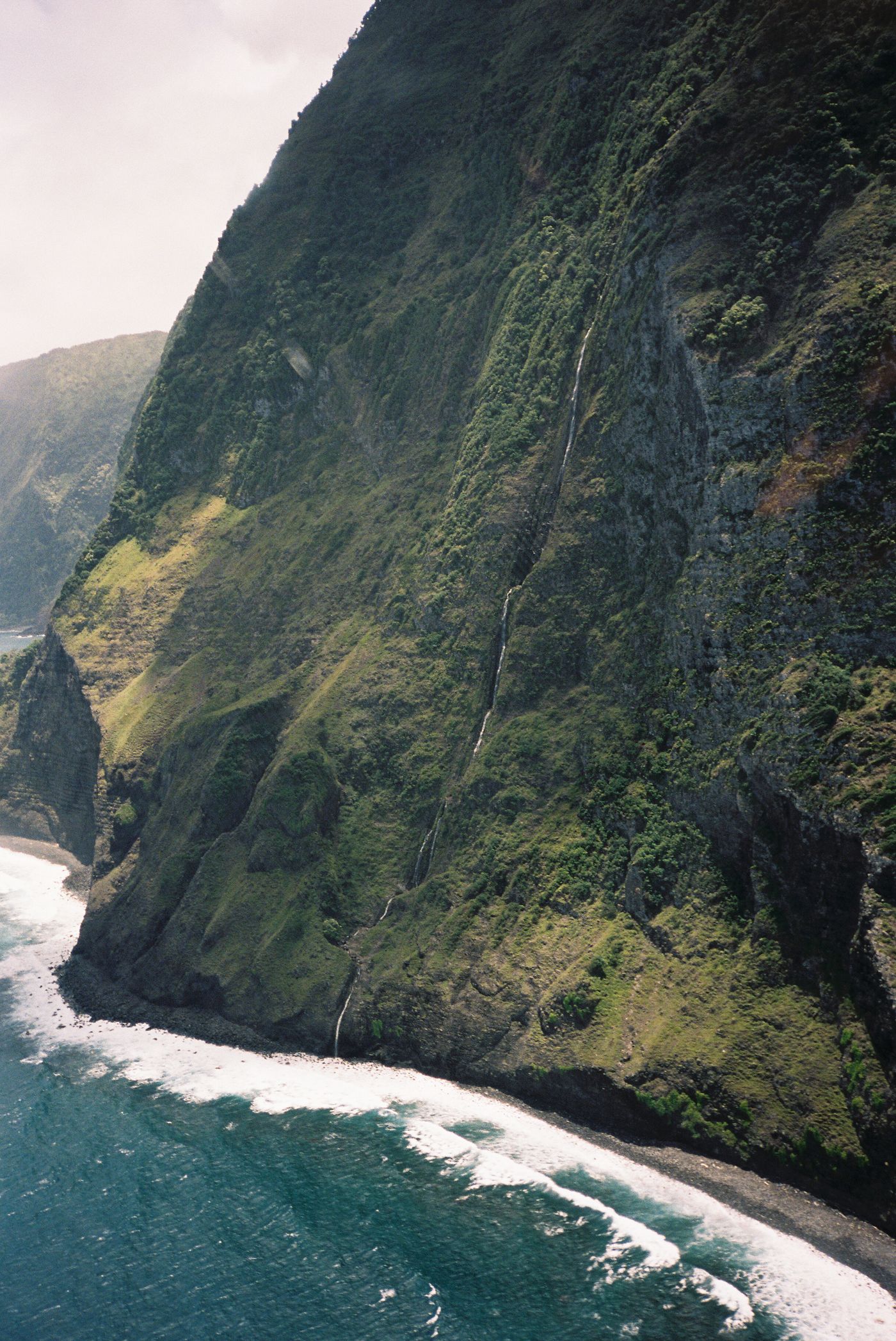 Green mountains meeting the sea on Molokaʻi