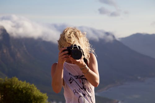 Person Taking Photo With Landscape Background