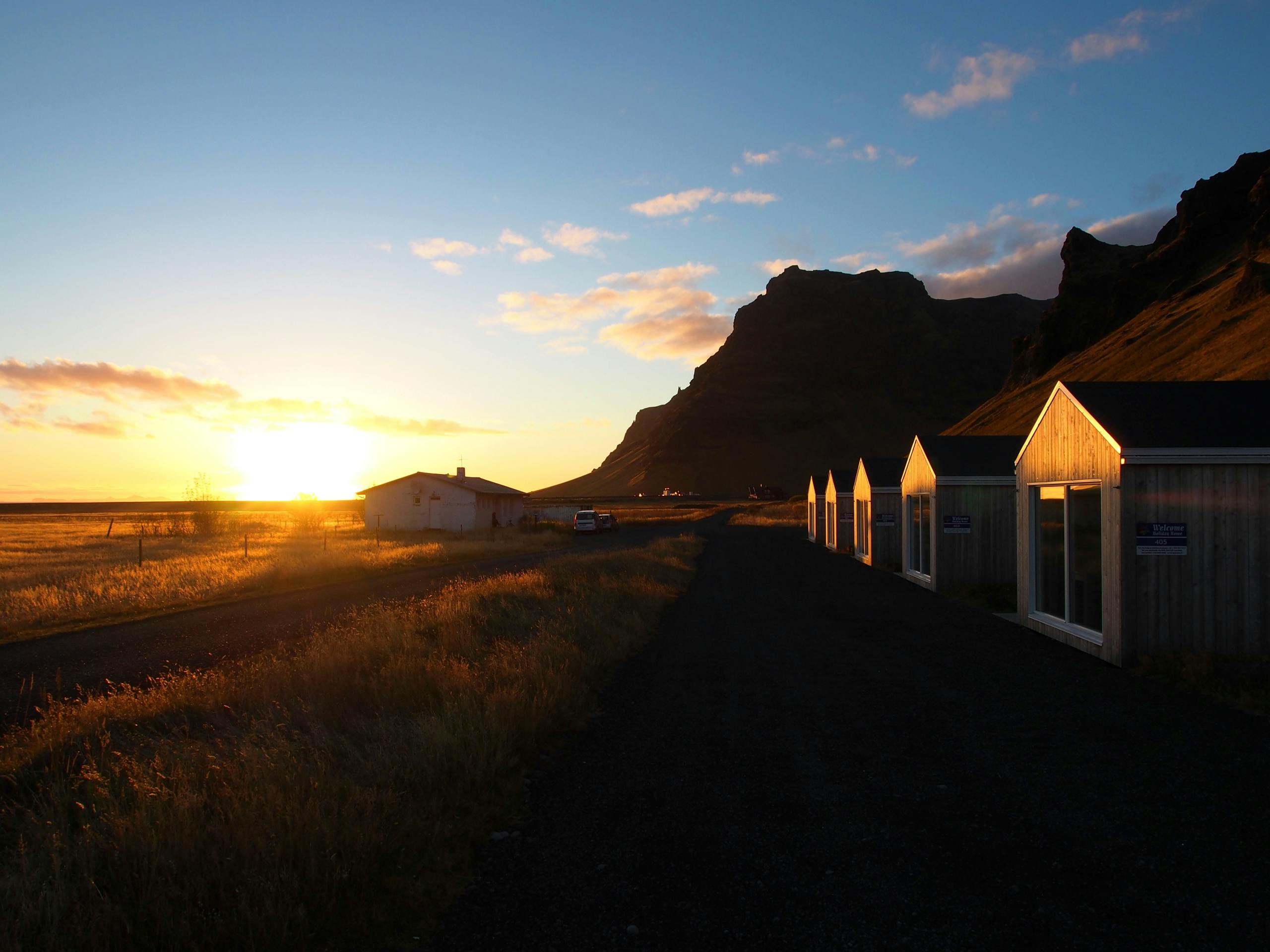 Free stock photo of golden sunset, grass, little houses