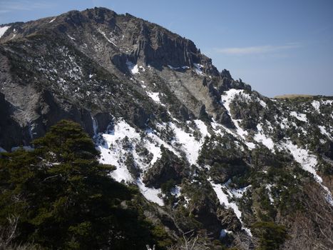 Breathtaking view of a snow-dusted mountain slope under a clear sky, showcasing natural winter beauty.