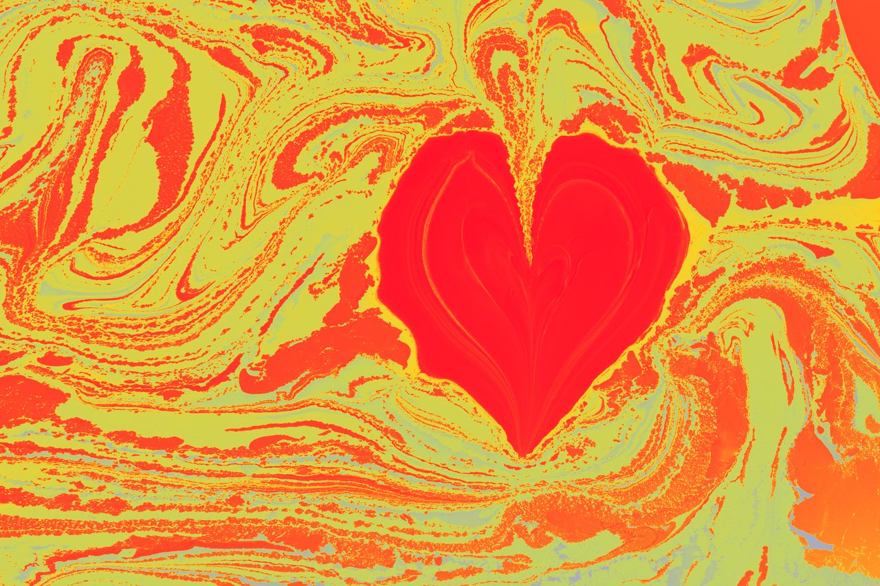 a vibrant red heart shape on a swirling abstract background of orange