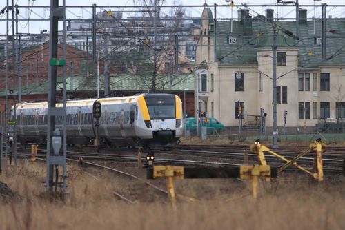 Free A train moves through complex railway lines near urban buildings, showcasing modern transportation. Stock Photo