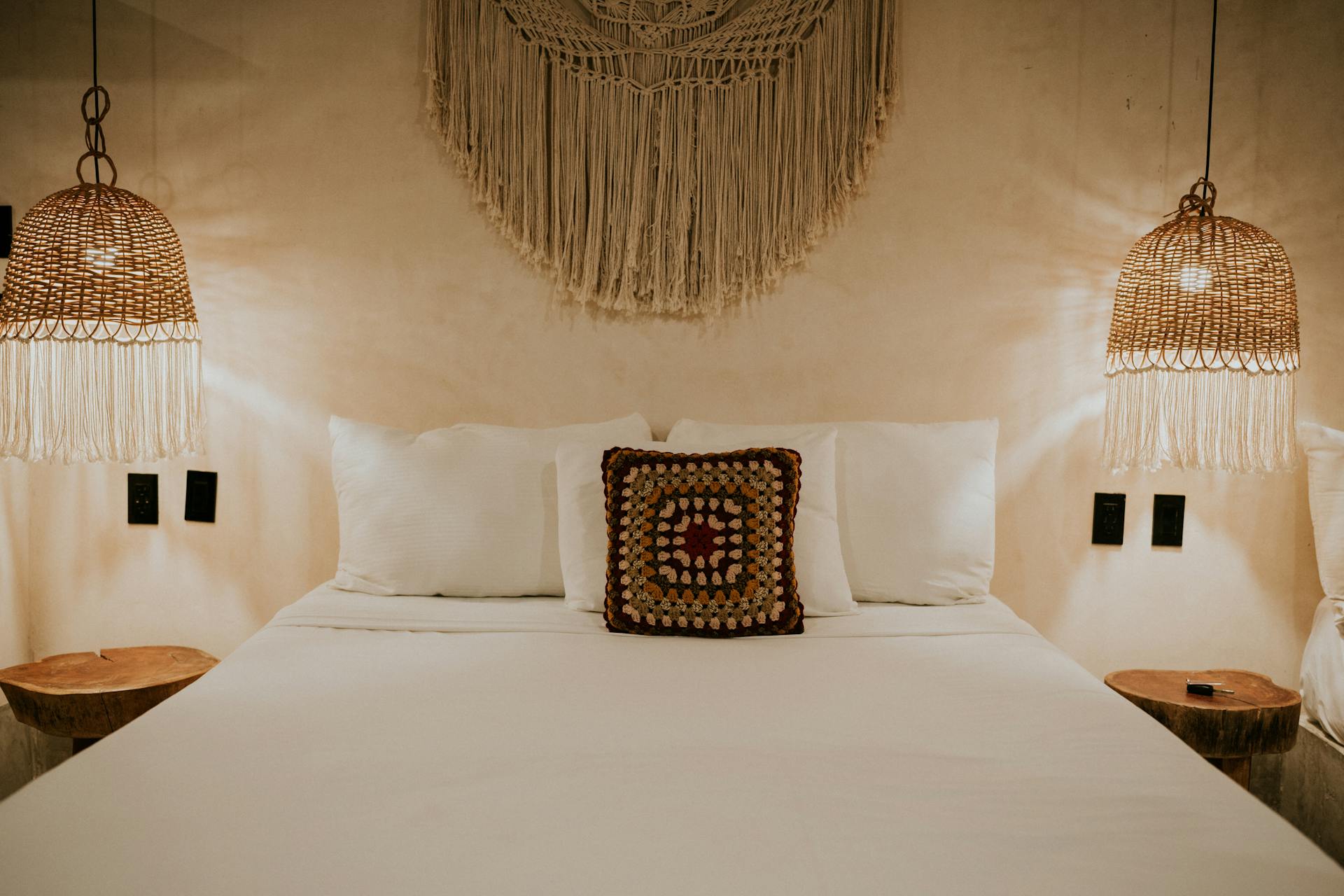 Warm bohemian bedroom with macrame decor and wicker lampshades for a cozy ambiance.