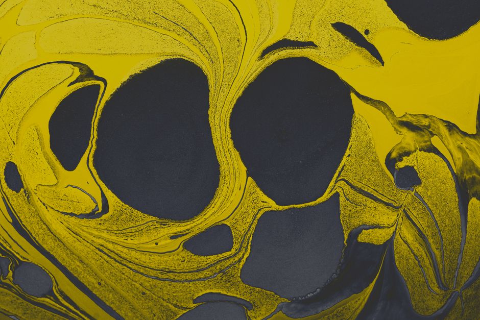 Vibrant yellow and black abstract marbled texture creating a dynamic visual impression.
