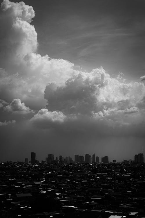 Monochrome Photo of City Under Cloudy Sky