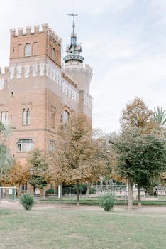 Elegant view of a historic castle with autumn trees in Barcelona, Spain.