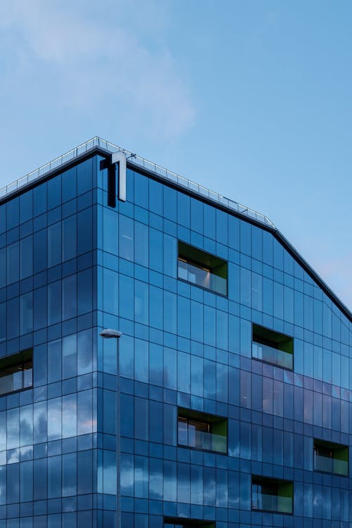 A Blue Glass Building Under the Blue Sky · Free Stock Photo