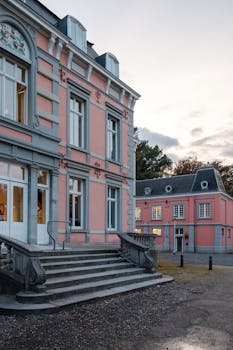 Beautiful pink mansion exterior showcasing ornate architecture during sunset.