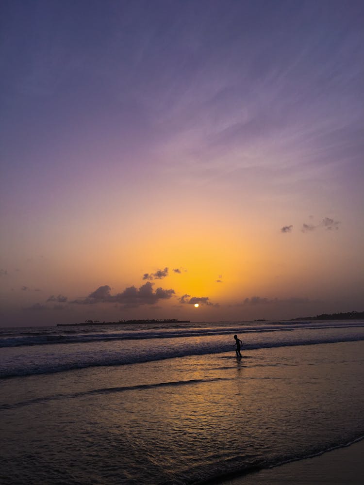 Child Walking In The Sea At Dusk 