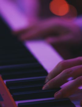 A close-up shot of a pianist's hands on a piano keyboard with bokeh effects, captured in Rome.