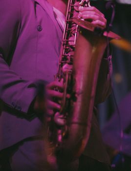 Close-up of a saxophonist performing live in Rome, Italy during a night event.