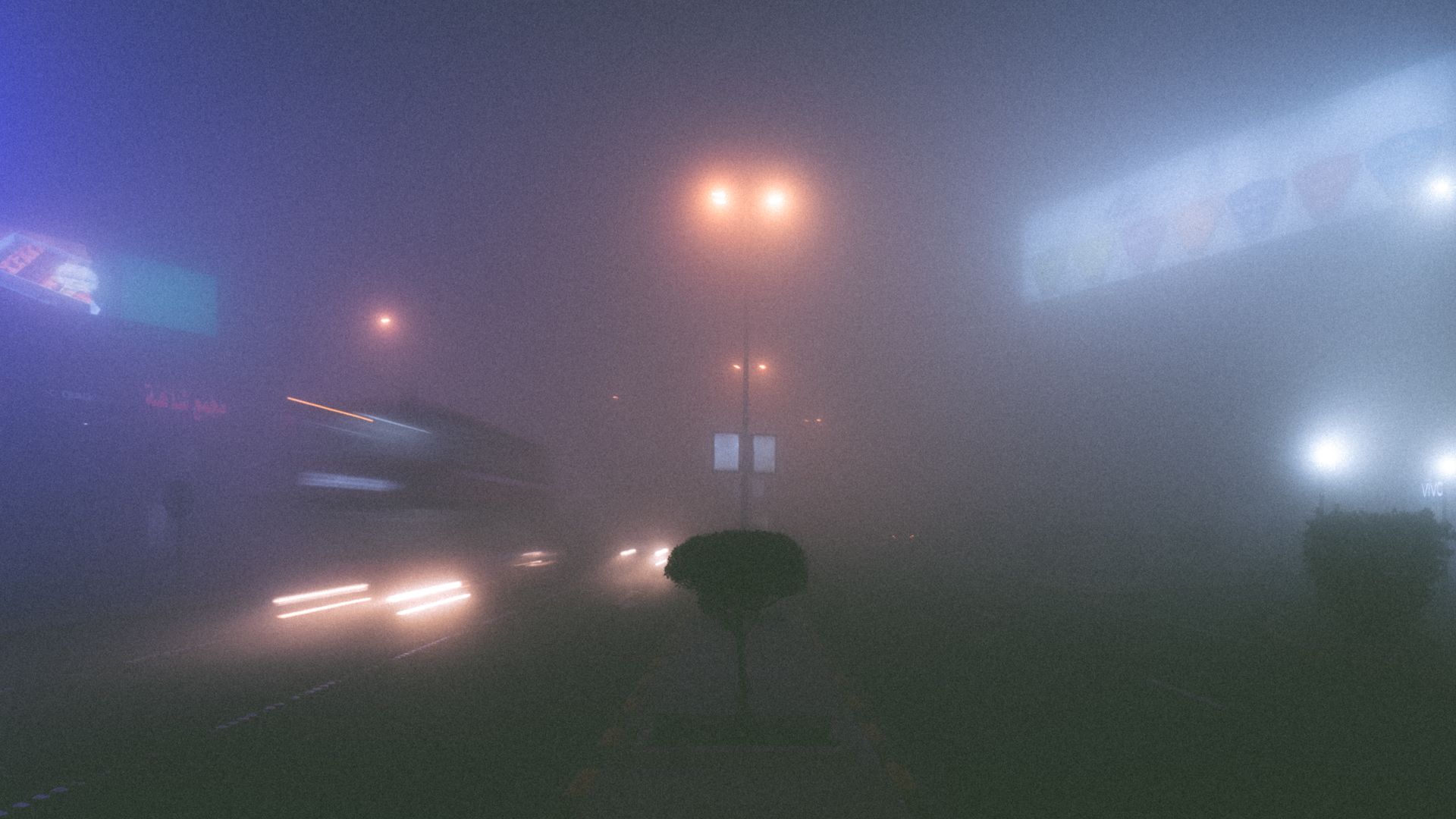 Misty evening street view in Kuwait City with blurred lights and foggy ambiance.
