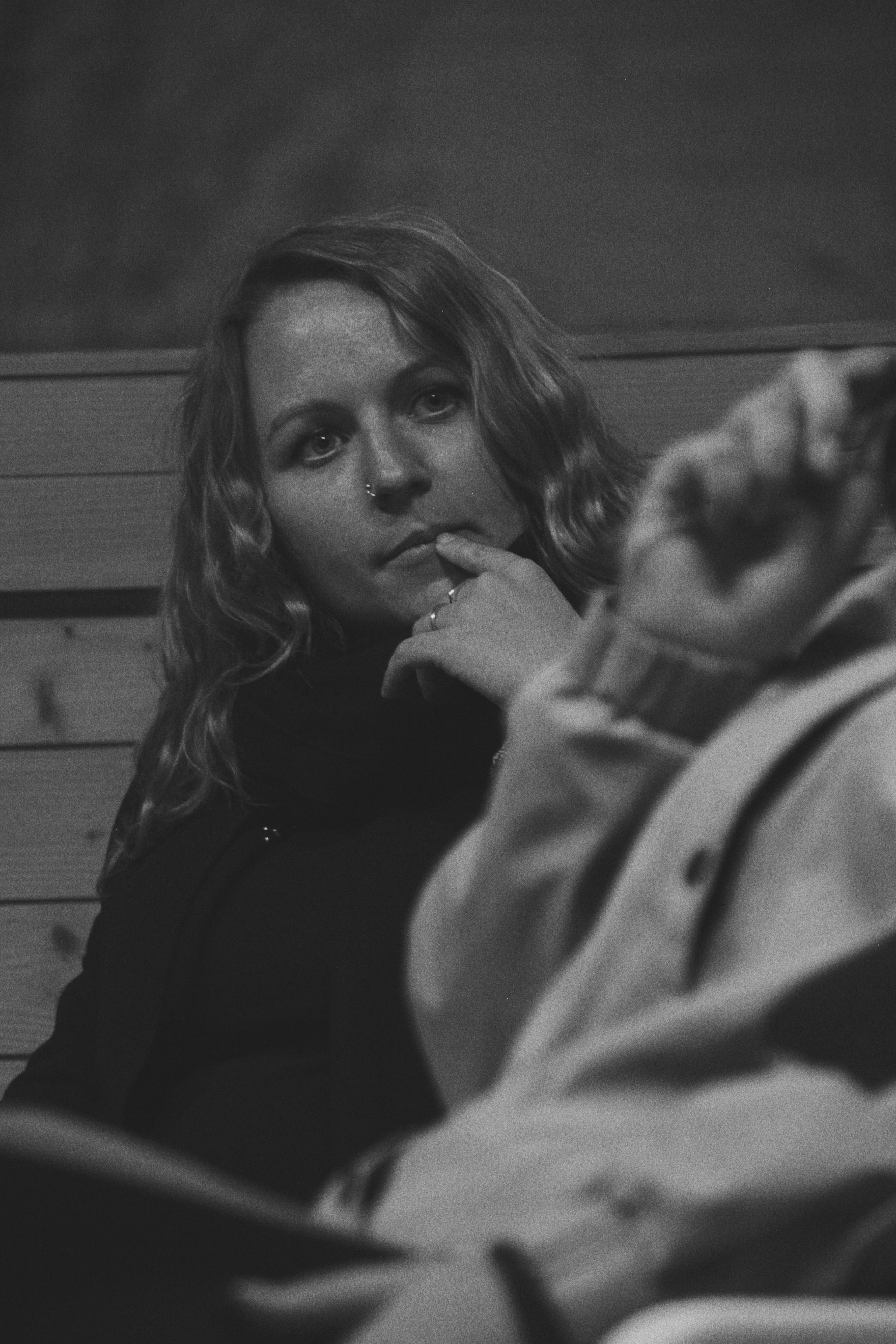 Introspective black and white portrait of a woman sitting and contemplating.