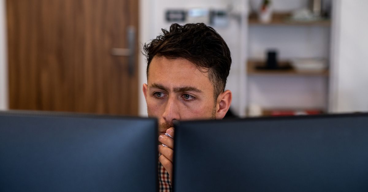 Working Man Staring at Computer Screens · Free Stock Photo