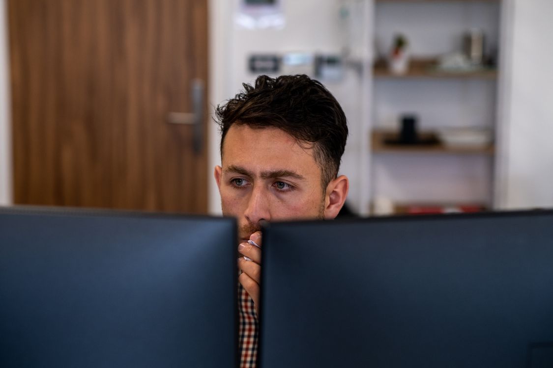 Working Man Staring at Computer Screens ยท Free Stock Photo