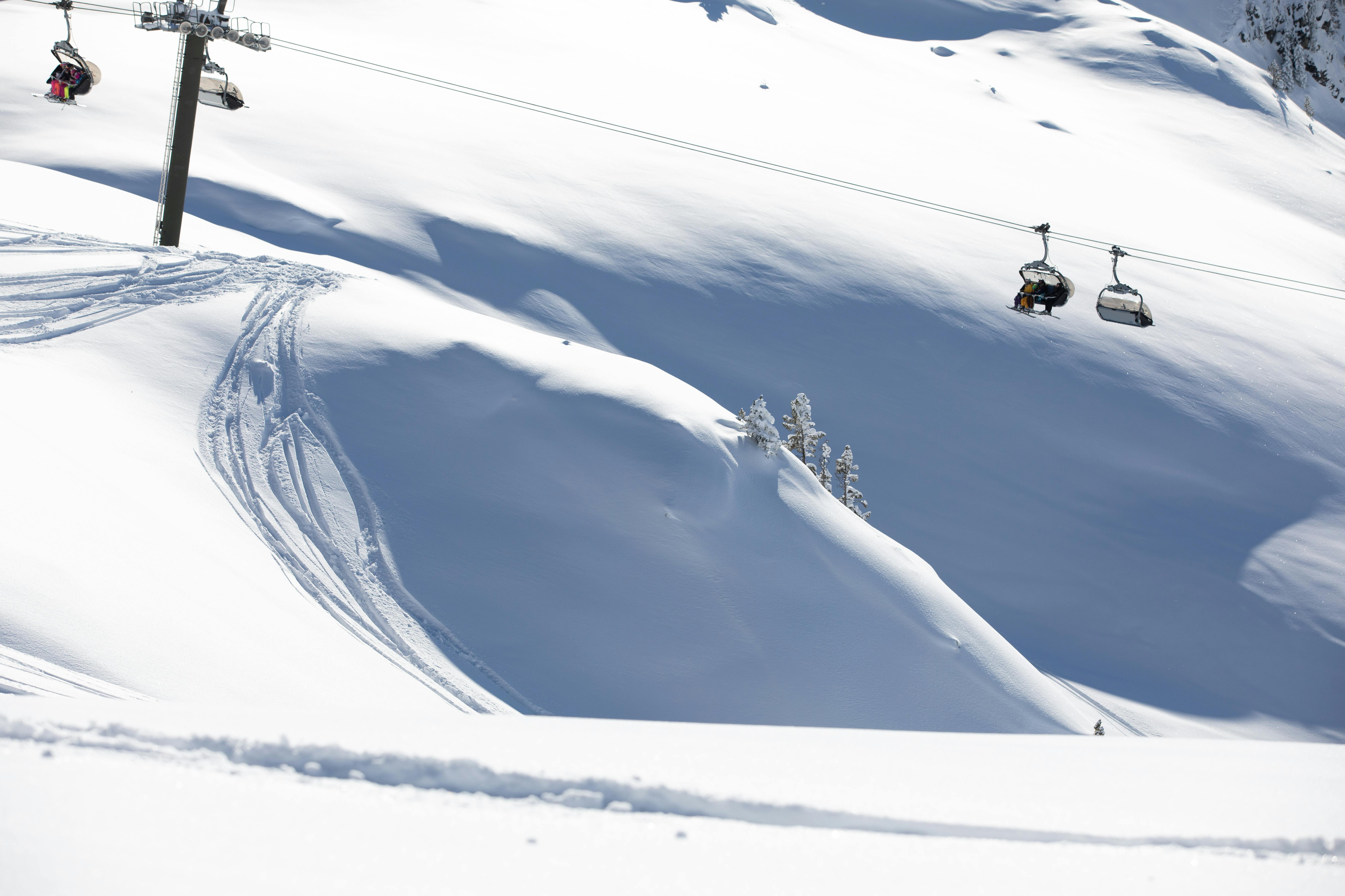 Ski lift transporting people over snowy slopes in a winter wonderland setting.