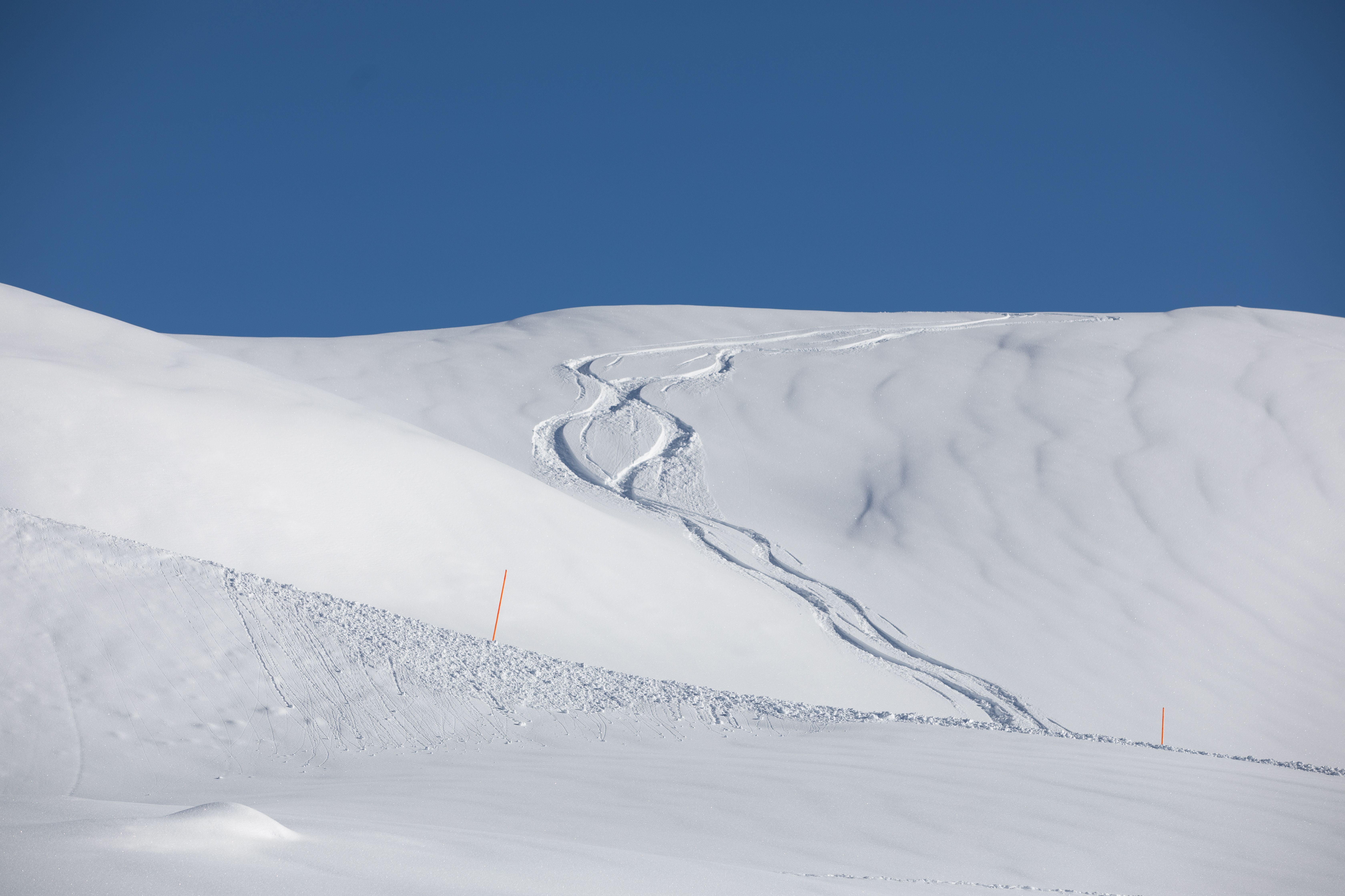 A skier performs a thrilling jump off a snowy mountainside, showcasing extreme winter sports.