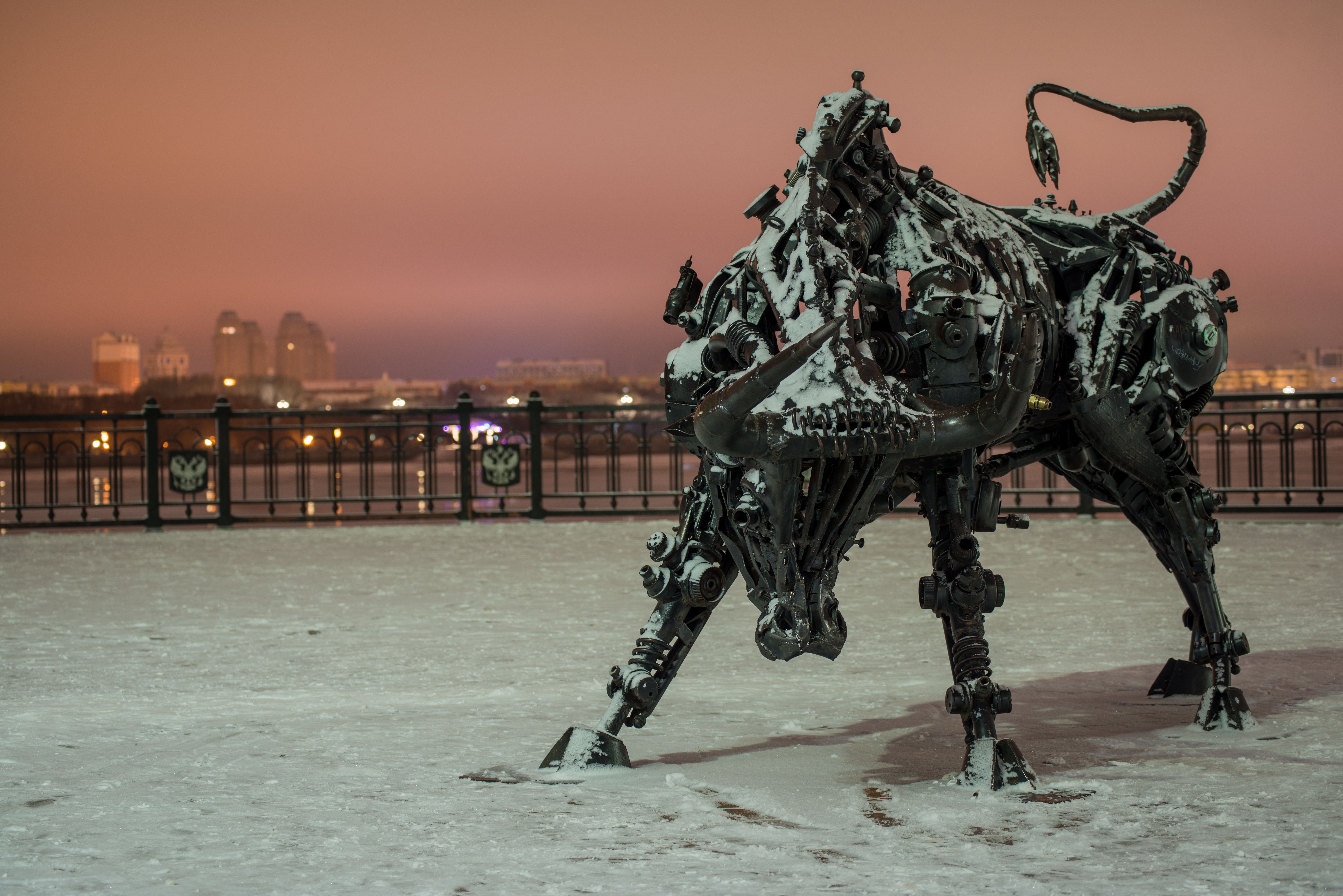 mechanical bull rental egypt — Impressive metal bull sculpture in snowy urban landscape at night.