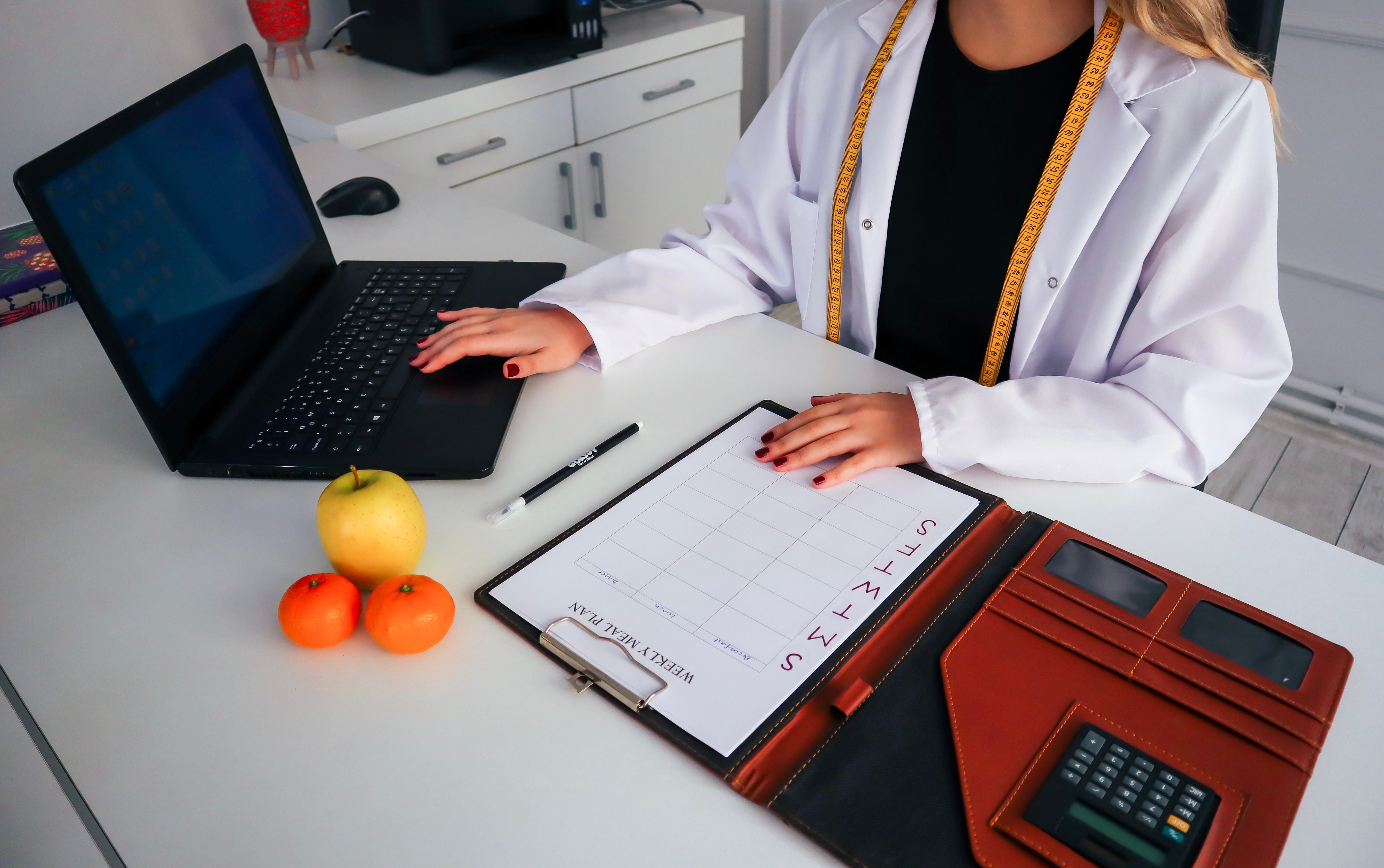 Dietitian planning a weekly meal planning routine to reduce decision fatigue with a laptop and calendar