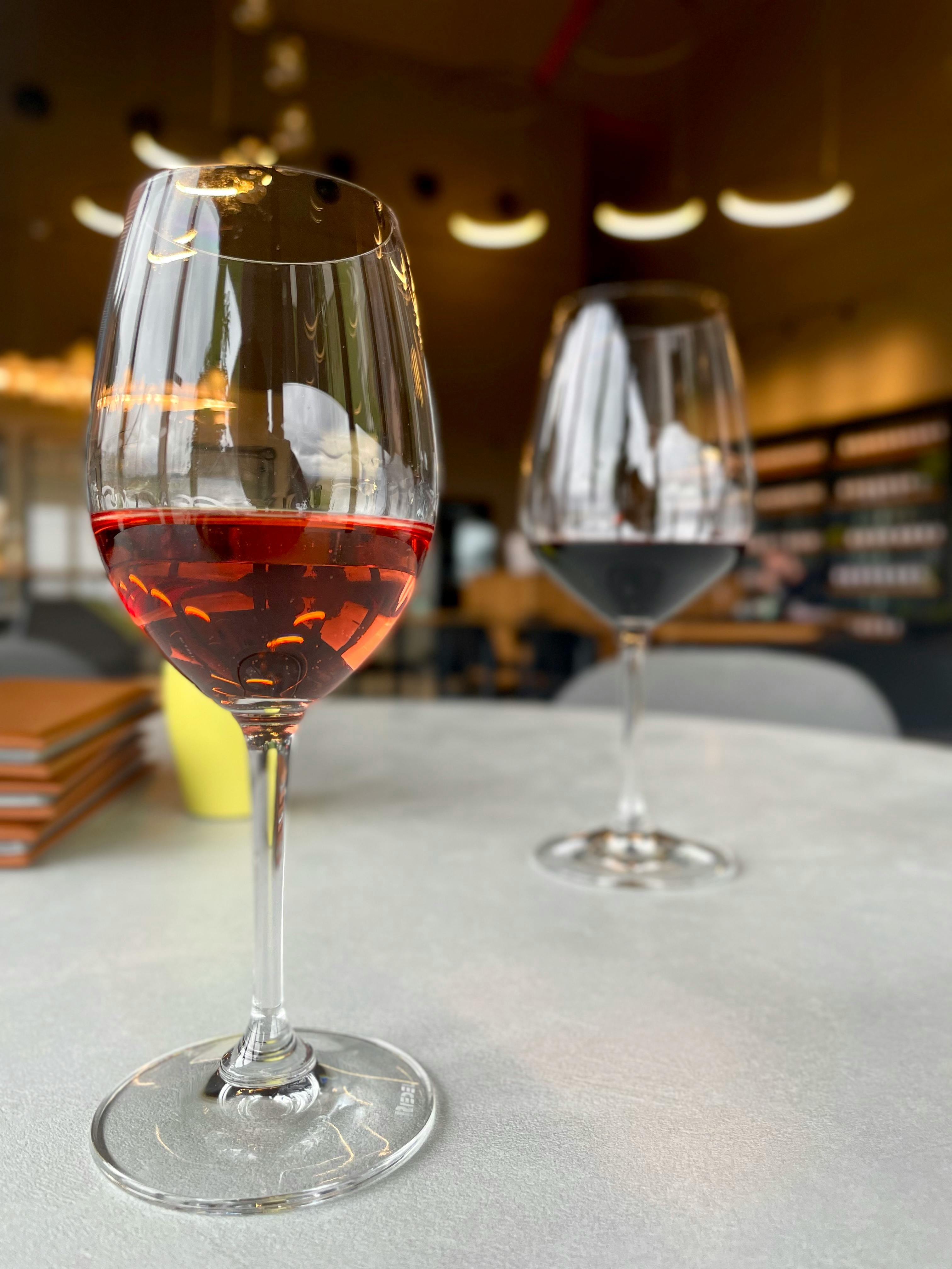 Two elegant wine glasses on a table in a cozy bistro in Negotin, Serbia.
