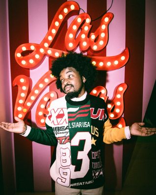 Free Stylish man posing in front of iconic Las Vegas sign indoors. Stock Photo