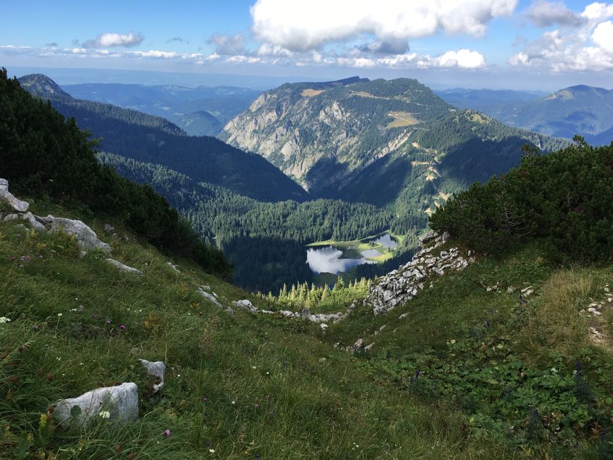 Uitzicht over een bergmeer vanaf een wandelpad in de Alpen