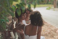 三个年轻女子坐在户外的长凳上，一起享受着阳光明媚的一天