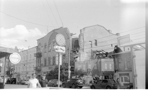 Free Black and white cityscape capturing people walking near old and destroyed buildings Stock Photo