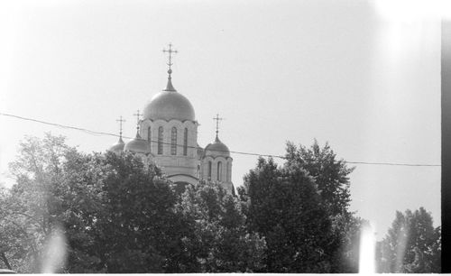 Free Black and white photo of a church dome amid trees, showcasing religious architecture. Stock Photo