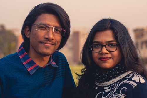 Free A warm portrait of two friends standing together outdoors during sunset. Stock Photo