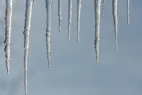 Free Detailed view of icicles hanging against a clear blue winter sky, showcasing frosty textures. Stock Photo