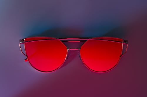 Kacamata Merah Di Permukaan Pink