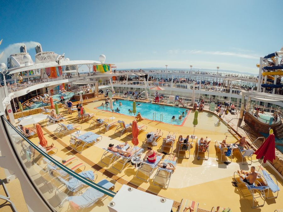 Passengers enjoying the pool deck of a huge cruise ship