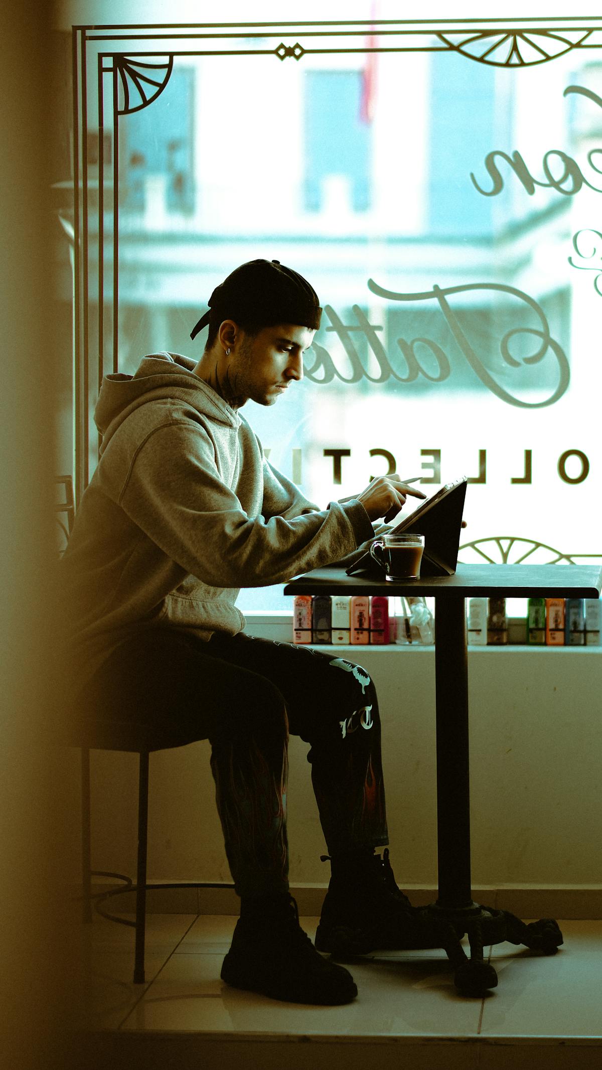 Persona seduta in caffè che utilizza un tablet per ordinare