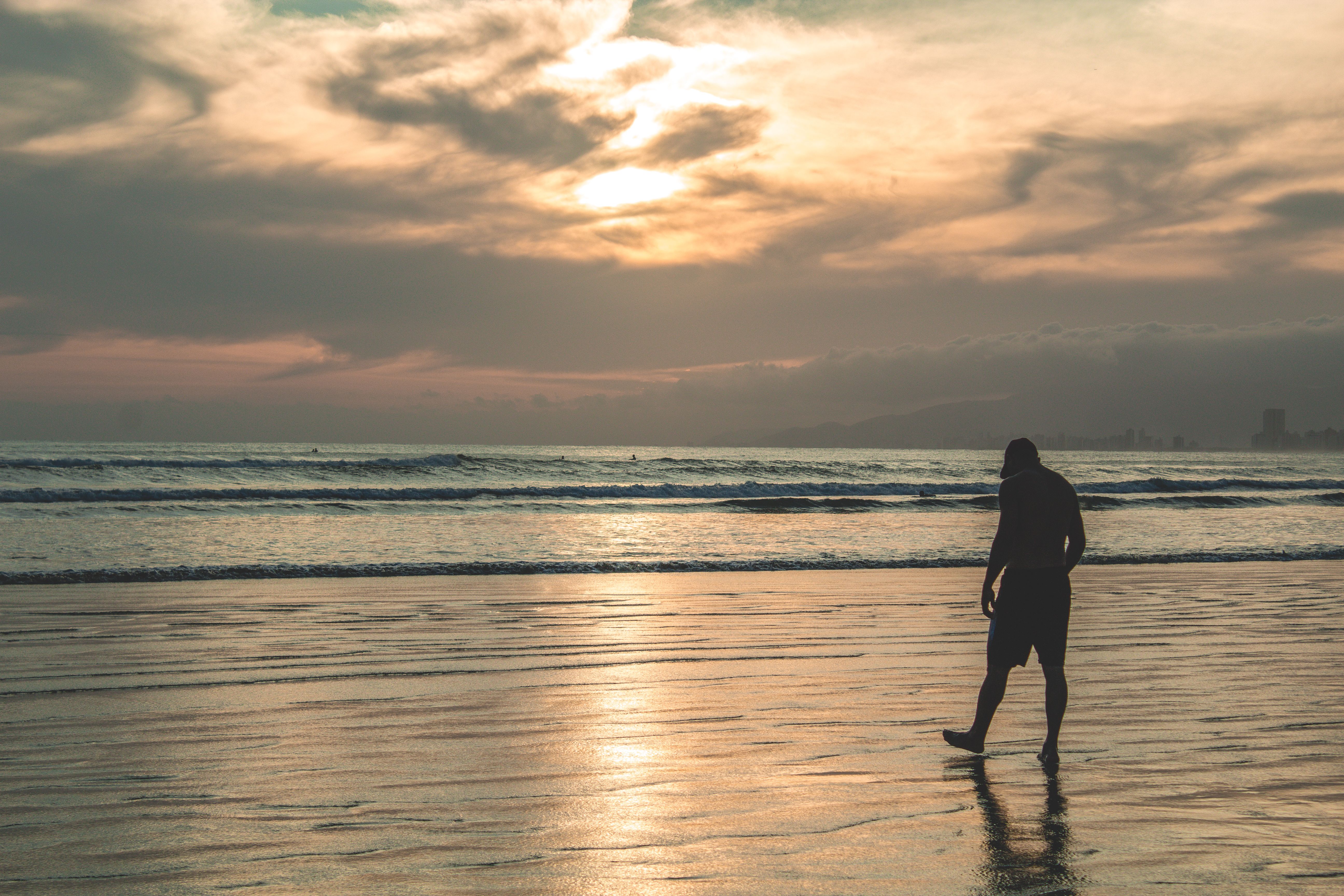 Late afternoon light over Praia da Joaquina with a surfer walking up the beach