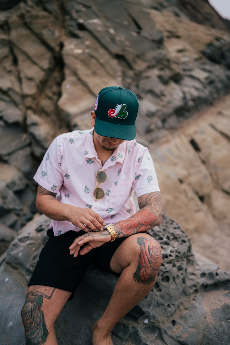 Man Sitting On The Rock And Checking His Wristwatch 