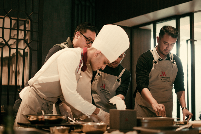 Team of chefs working together in a modern restaurant kitchen, preparing gourmet dishes with precision and skill.